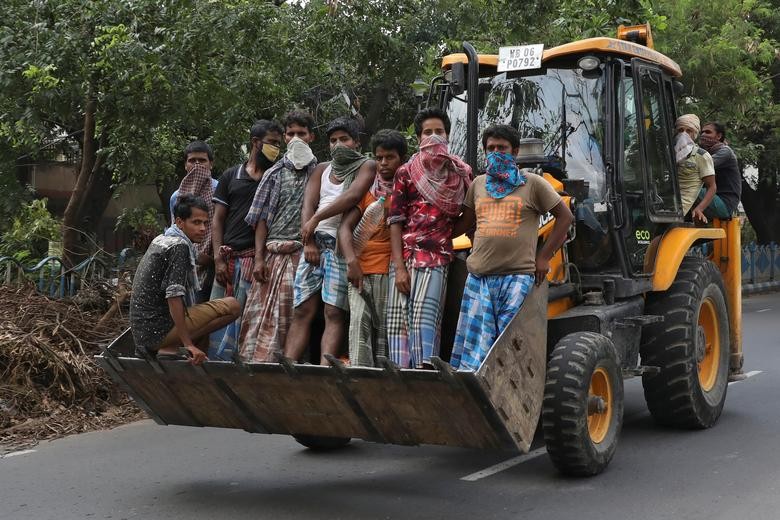 Labourers ride in the bucket of a payloader to their worksite after some restrictions were lifted during an extended nationwide lockdown to slow the spread of the coronavirus disease (COVID-19), in Kolkata, India, June 2, 2020. REUTERS/Rupak De Chowdhuri